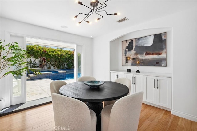 dining area featuring an inviting chandelier, baseboards, visible vents, and light wood-type flooring