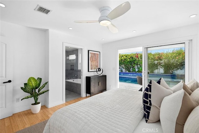 bedroom featuring visible vents, ensuite bathroom, wood finished floors, baseboards, and access to exterior