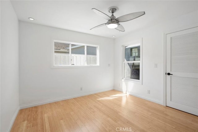 unfurnished room with plenty of natural light, baseboards, and light wood finished floors