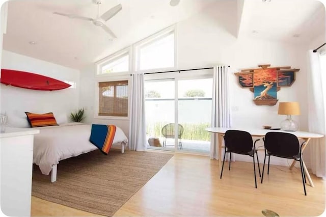 bedroom featuring a ceiling fan, access to exterior, wood finished floors, and high vaulted ceiling