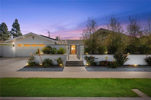 view of front facade with stucco siding, roof mounted solar panels, fence, concrete driveway, and an attached garage