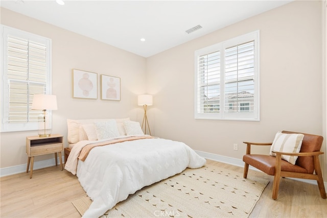 bedroom with wood finished floors, baseboards, and recessed lighting