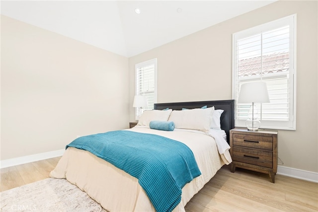bedroom featuring wood finished floors, baseboards, and vaulted ceiling