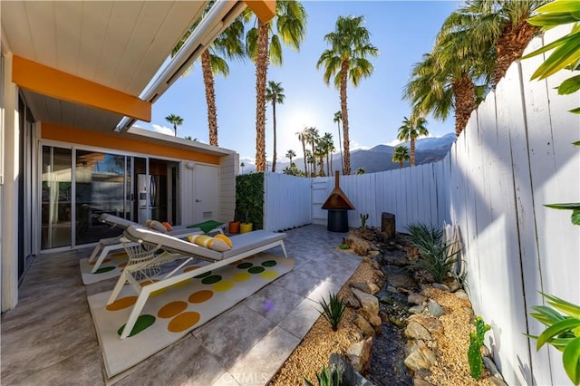 view of yard featuring a patio area, a fenced backyard, and a mountain view