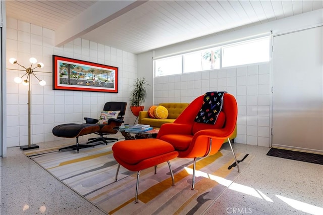 sitting room with beamed ceiling and speckled floor