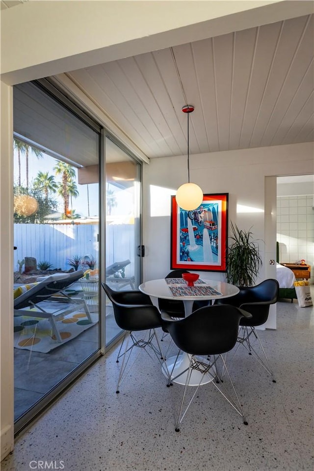 dining area with wood ceiling and speckled floor