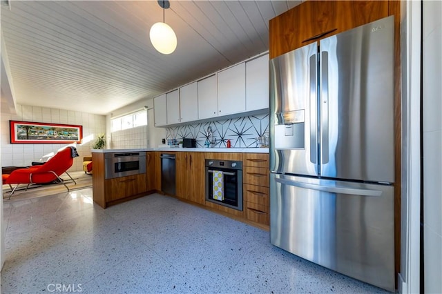 kitchen with brown cabinetry, stainless steel fridge with ice dispenser, oven, decorative light fixtures, and light countertops