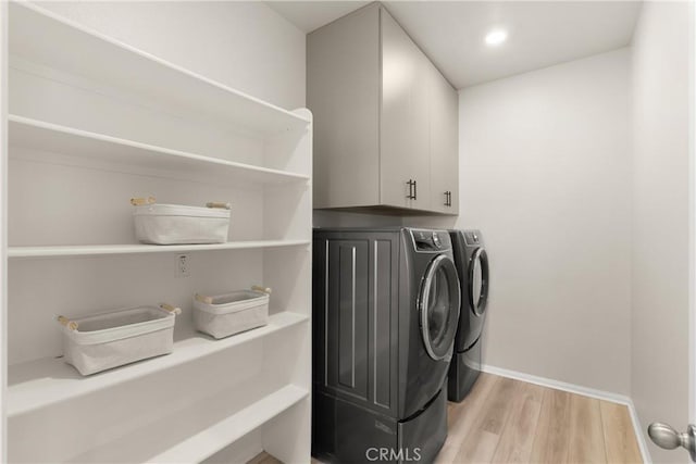 laundry area with light wood finished floors, washer and clothes dryer, baseboards, recessed lighting, and cabinet space