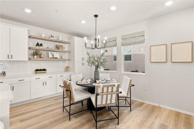 dining room with light wood finished floors, recessed lighting, and an inviting chandelier