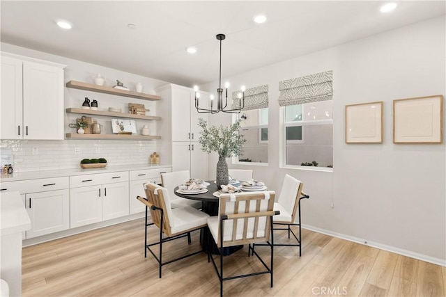 dining room with light wood-type flooring, baseboards, recessed lighting, and a notable chandelier