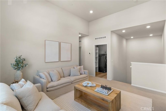 living area with washer / dryer, carpet flooring, visible vents, and recessed lighting