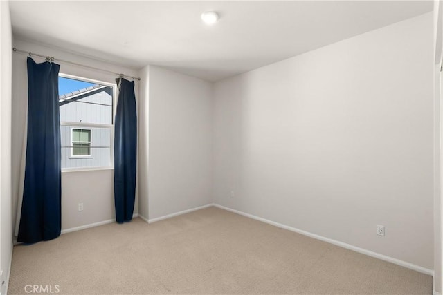 unfurnished room featuring carpet and baseboards