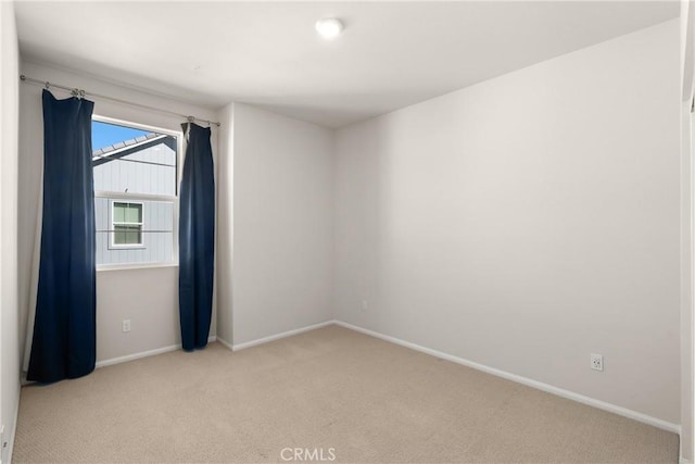 spare room featuring carpet floors and baseboards