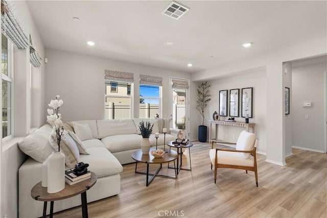 living room with light wood-style floors, baseboards, visible vents, and recessed lighting