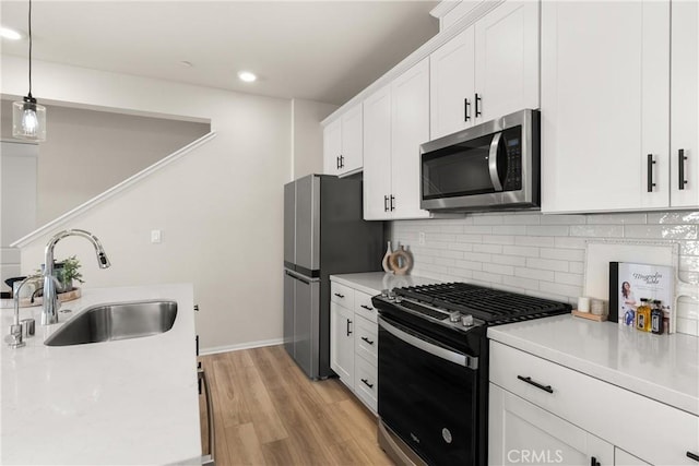 kitchen with light countertops, a sink, and appliances with stainless steel finishes