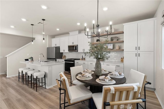 dining space featuring light wood-style floors, baseboards, visible vents, and recessed lighting