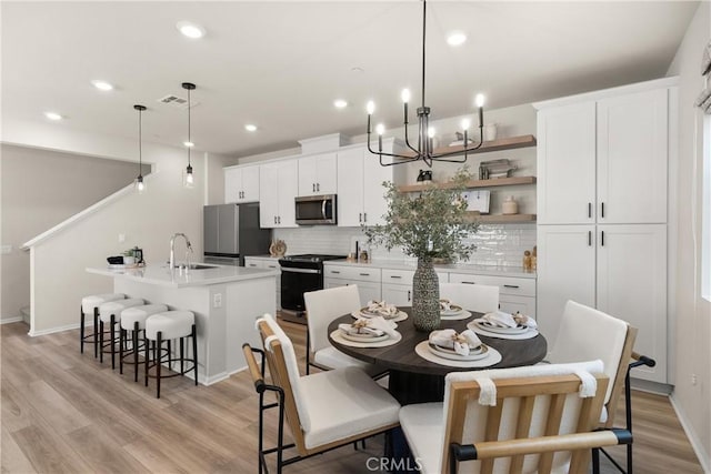 dining room featuring recessed lighting, visible vents, light wood-style floors, baseboards, and a notable chandelier