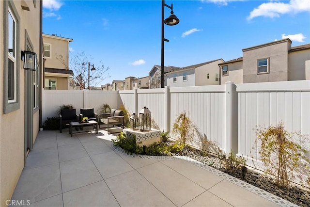 view of patio / terrace featuring an outdoor living space, a fenced backyard, and a residential view