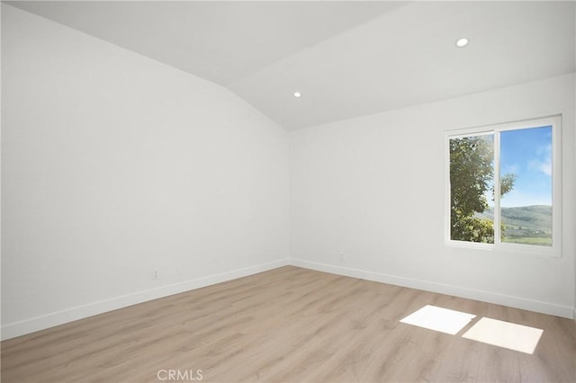 empty room with lofted ceiling, baseboards, light wood finished floors, and recessed lighting