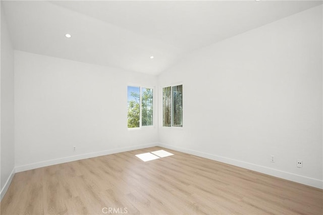 unfurnished room featuring lofted ceiling, recessed lighting, light wood-type flooring, and baseboards