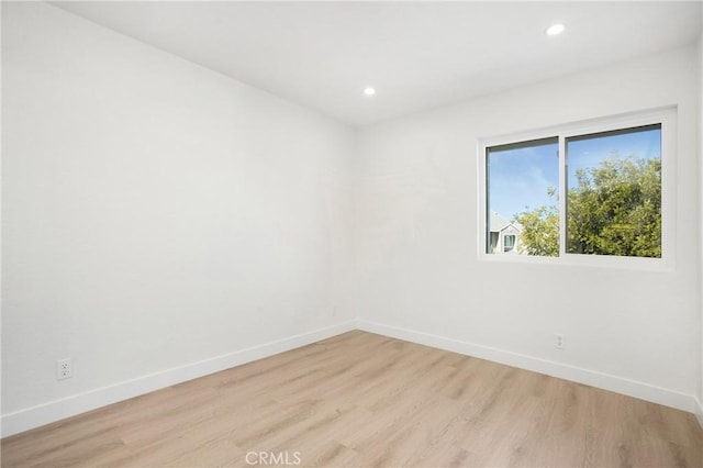 empty room featuring recessed lighting, light wood-style flooring, and baseboards