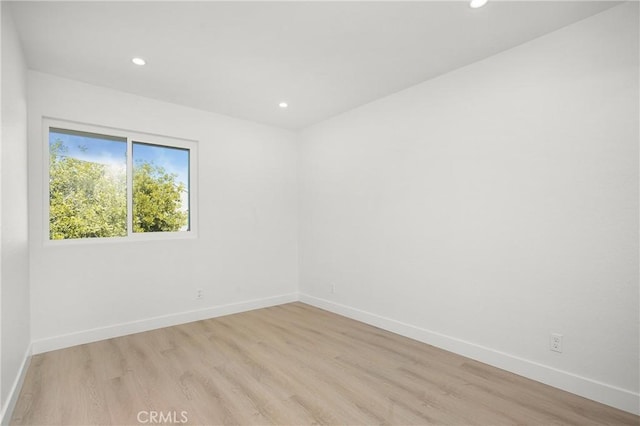 spare room with light wood-style floors, recessed lighting, and baseboards