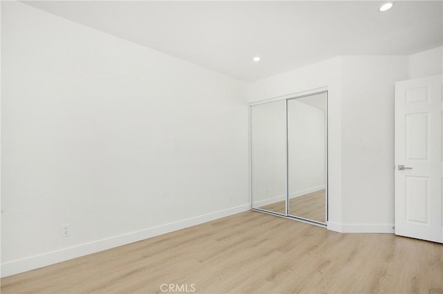 unfurnished bedroom with light wood-style floors, recessed lighting, a closet, and baseboards