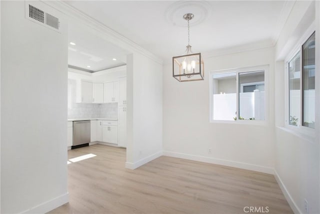 unfurnished dining area with baseboards, visible vents, and crown molding