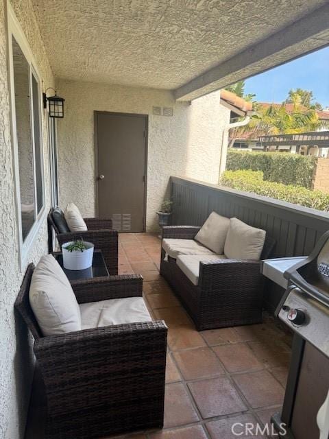 view of patio with an outdoor living space, visible vents, and a balcony