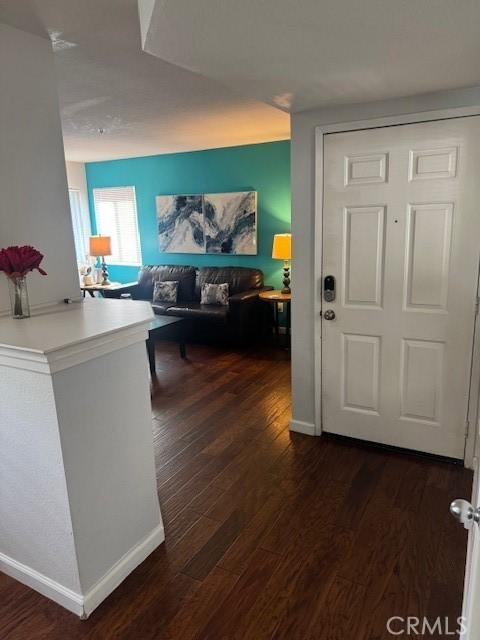 hall with dark wood-style floors and baseboards