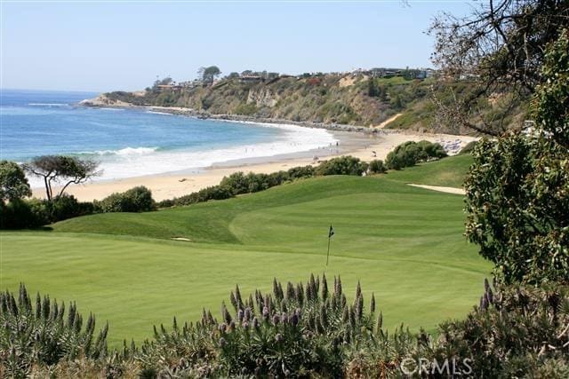 surrounding community featuring golf course view, a water view, and a lawn