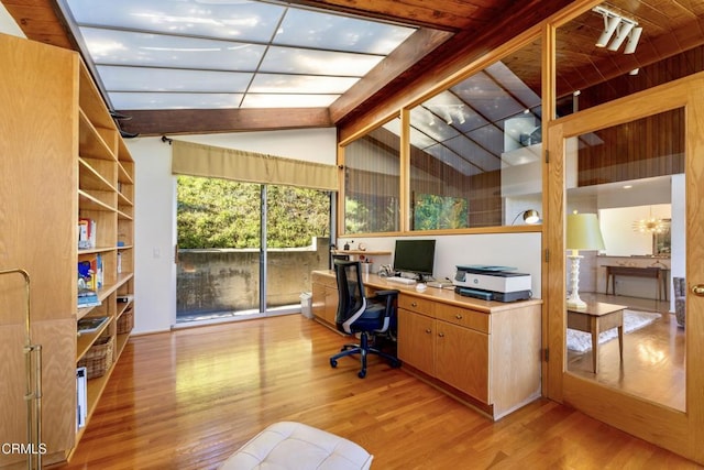 home office with lofted ceiling with beams and light wood-style floors