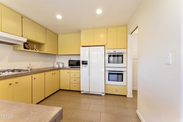 kitchen with white appliances, backsplash, open shelves, and light countertops