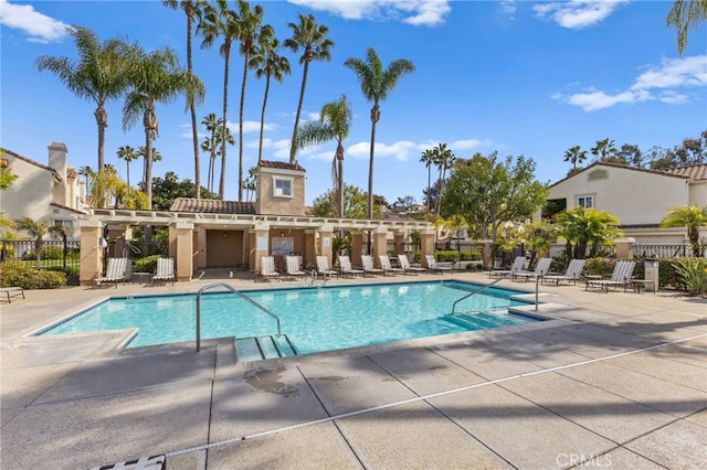 community pool with fence and a patio