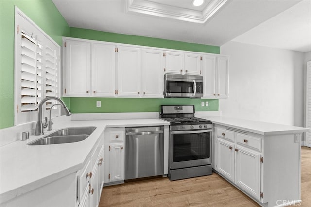 kitchen with appliances with stainless steel finishes, white cabinetry, and a sink