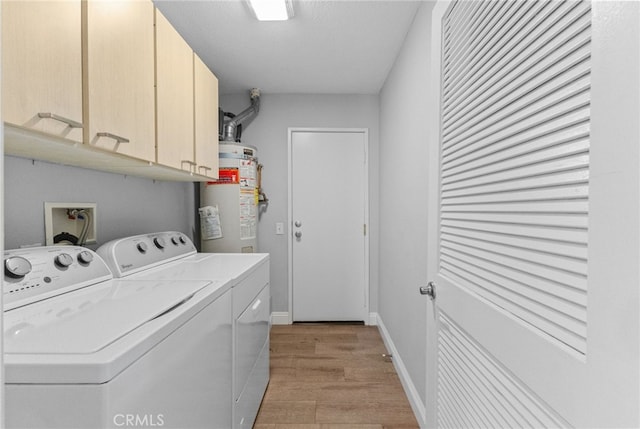 washroom featuring strapped water heater, light wood finished floors, cabinet space, independent washer and dryer, and baseboards