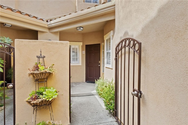 entrance to property with a tiled roof and stucco siding