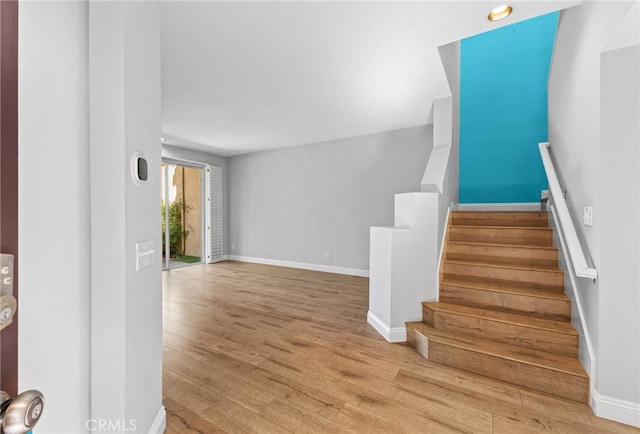 stairway with baseboards and wood finished floors