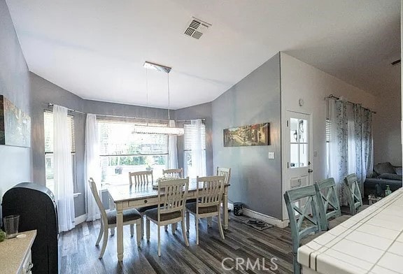 dining space featuring baseboards, visible vents, and dark wood finished floors