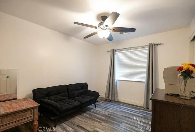 living room with dark wood-style floors, baseboards, and a ceiling fan