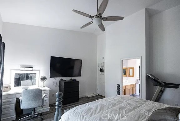 bedroom featuring a towering ceiling, dark wood-type flooring, connected bathroom, and a ceiling fan