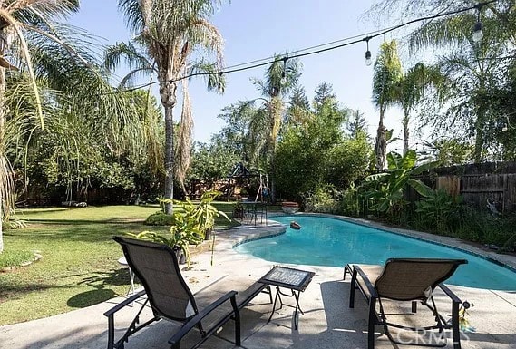 view of pool featuring a fenced in pool, fence, a patio, and a yard