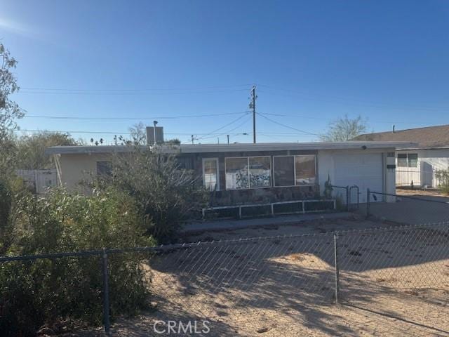 ranch-style home with a garage, a fenced front yard, and concrete driveway