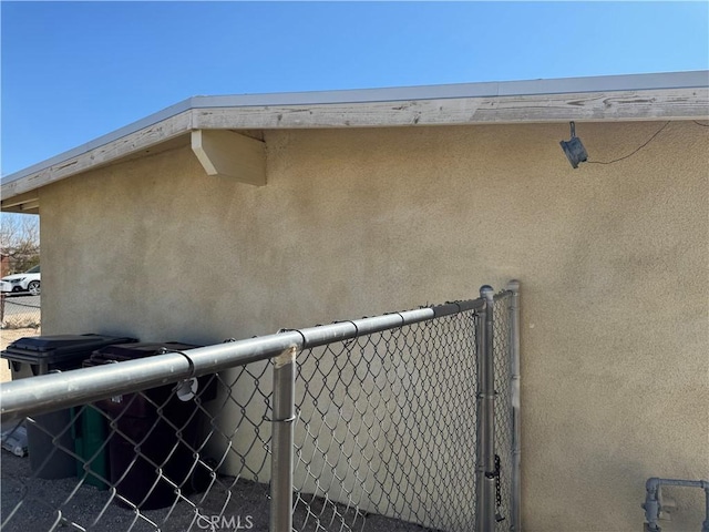 details featuring fence and stucco siding