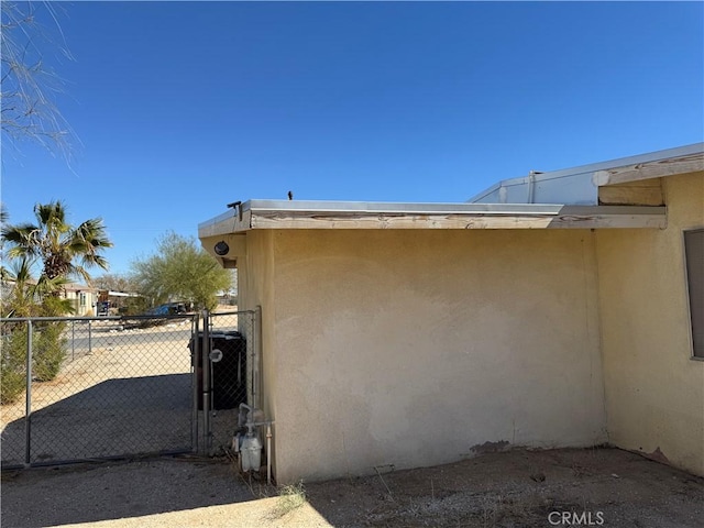 view of side of home with fence and stucco siding