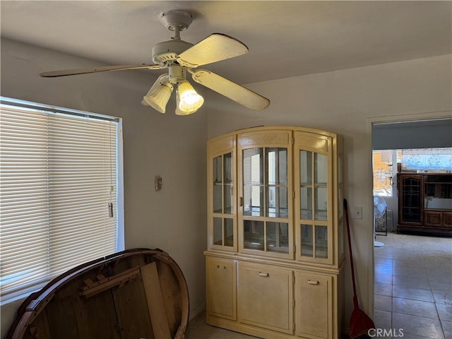 interior space with light tile patterned flooring and ceiling fan