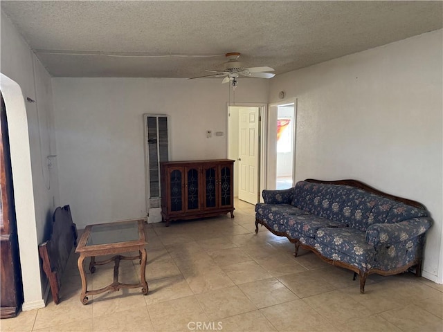 living room with a textured ceiling and a ceiling fan