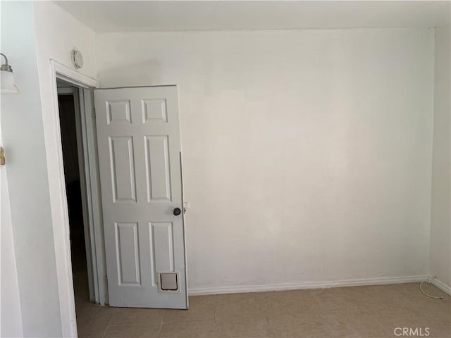 spare room with baseboards