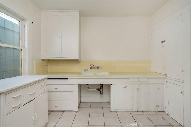 bathroom featuring tile patterned flooring, decorative backsplash, and a sink