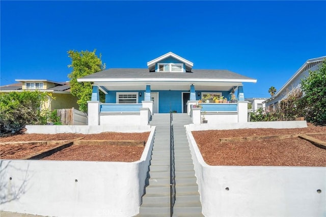 view of front of home featuring a fenced front yard, a porch, and stucco siding